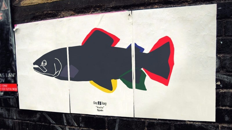 Photograph of a poster in three pieces stuck on a street with the Trucha drawing.