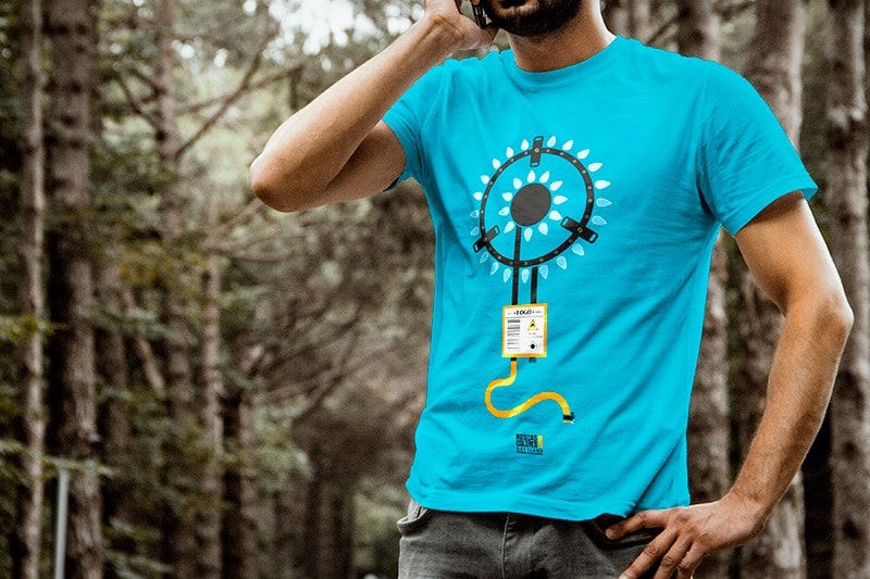 Fotografía en plano corto de un chico en un bosque, que habla por el móvil y que lleva una camiseta con la ilustración Fogó.