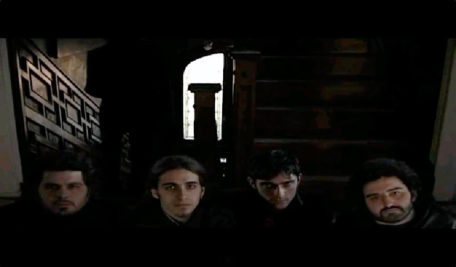 Fotograma del vídeo de la canción “El hombre que casi conoció a Michi Panero” en la que se ve a 4 hombres desde arriba mirando a la cámara.