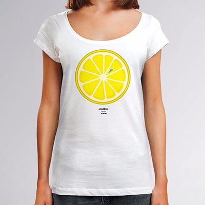 Fotografía en primer plano de una camiseta blanca que lleva una chica con el diseño Lemon, una rodaja de limón vista de frente en colores blanco, amarillo y verde.