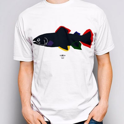 Close-up photograph of a white T-shirt worn by a boy with the Trucha drawing, in black, red, blue, green and yellow colors.