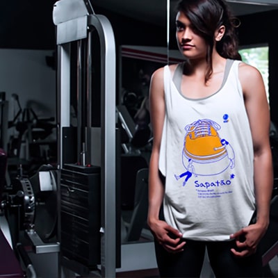 Fotrografía en color de una chica en un gimnasio, llevando una camiseta con el diseño Sapatão.