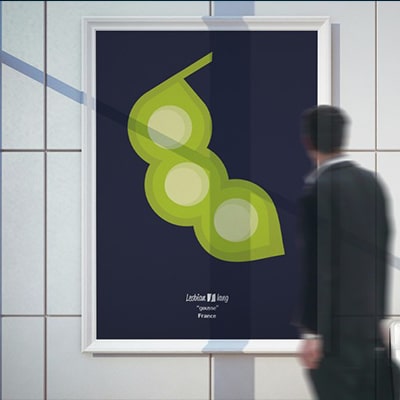 Fotografía en color de un póster con el diseño Gousse, colgado de una pared, contemplado por un hombre borroso.